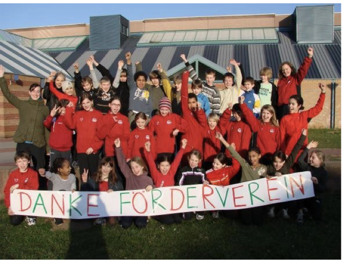 Kinder und Jugendliche des asc Darmstadt halten ein selbst gemaltes Banner mit der Aufschrift „Danke Förderverein“ hoch.